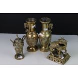 A pair of oriental brass vases together with a brass dog of foo and a brass urn.