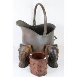 A copper coal bucket together with a pair of tribal carved wooden books ends and a wooden brush pot.