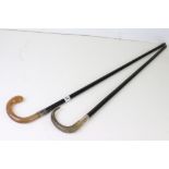 Two vintage ebonised walking sticks with horn handles and silver collars.