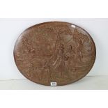 An asian decorative copper wall plaque with repousse scene.