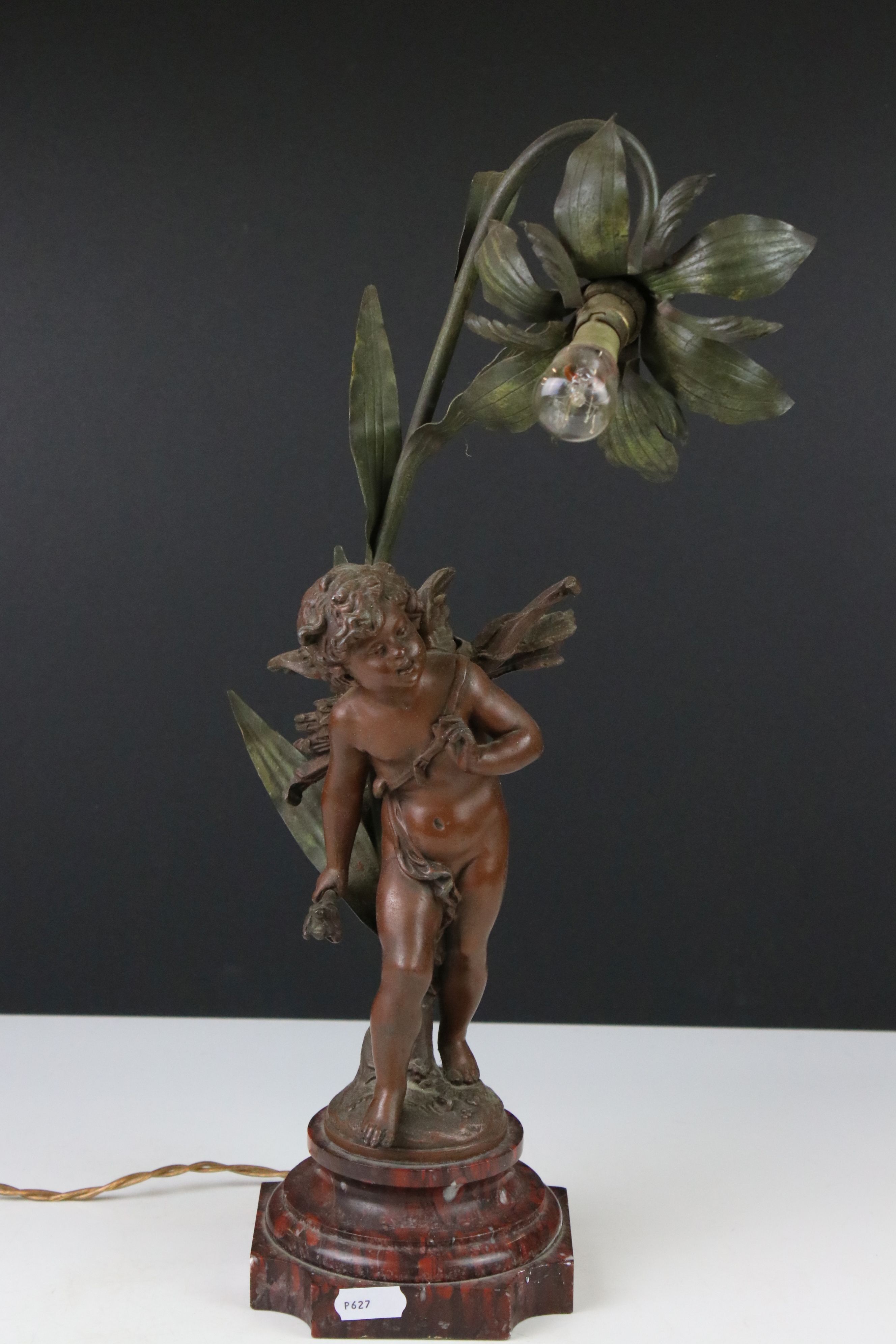 An early 20th century cast lamp in the form of a flower and cherub.