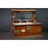 An antique oak tantalus with ornate brass decoration.