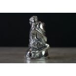 Silver plated vesta case in the form of a female figure holding a phallic object, signed
