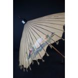 An oriental silk parasol with hand painted floral and scenic decoration.
