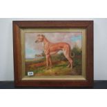 Oil painting study of a lurcher dog on a grassy hillside, contained in an oak frame