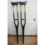 A pair of ebonised wooden crutches with brass fittings.