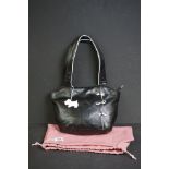 A black Radley handbag with white bow detailing, white Radley dog and pink dust bag.