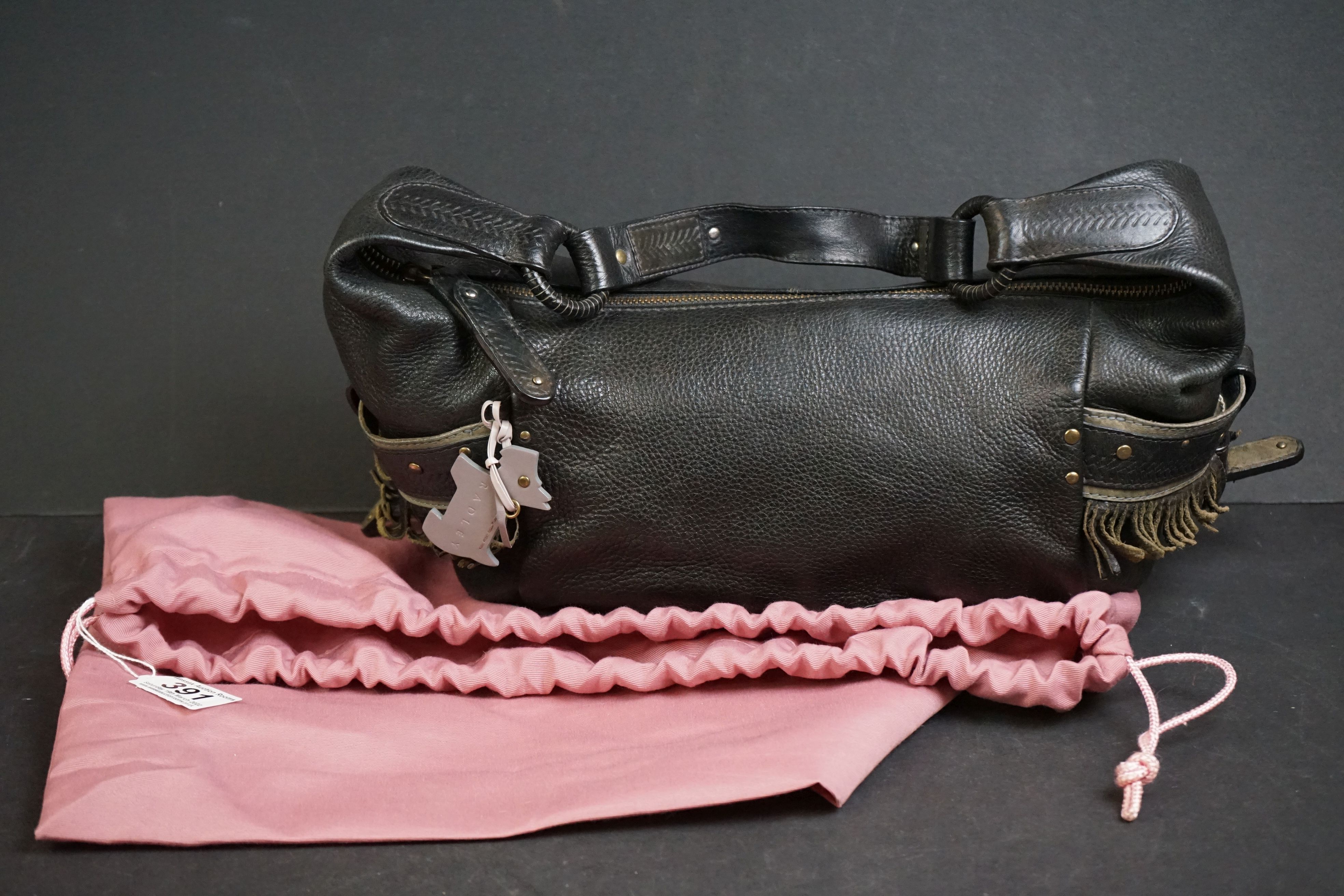 A black Radley handbag with fringed detail, grey Radley dog and pink dust bag.
