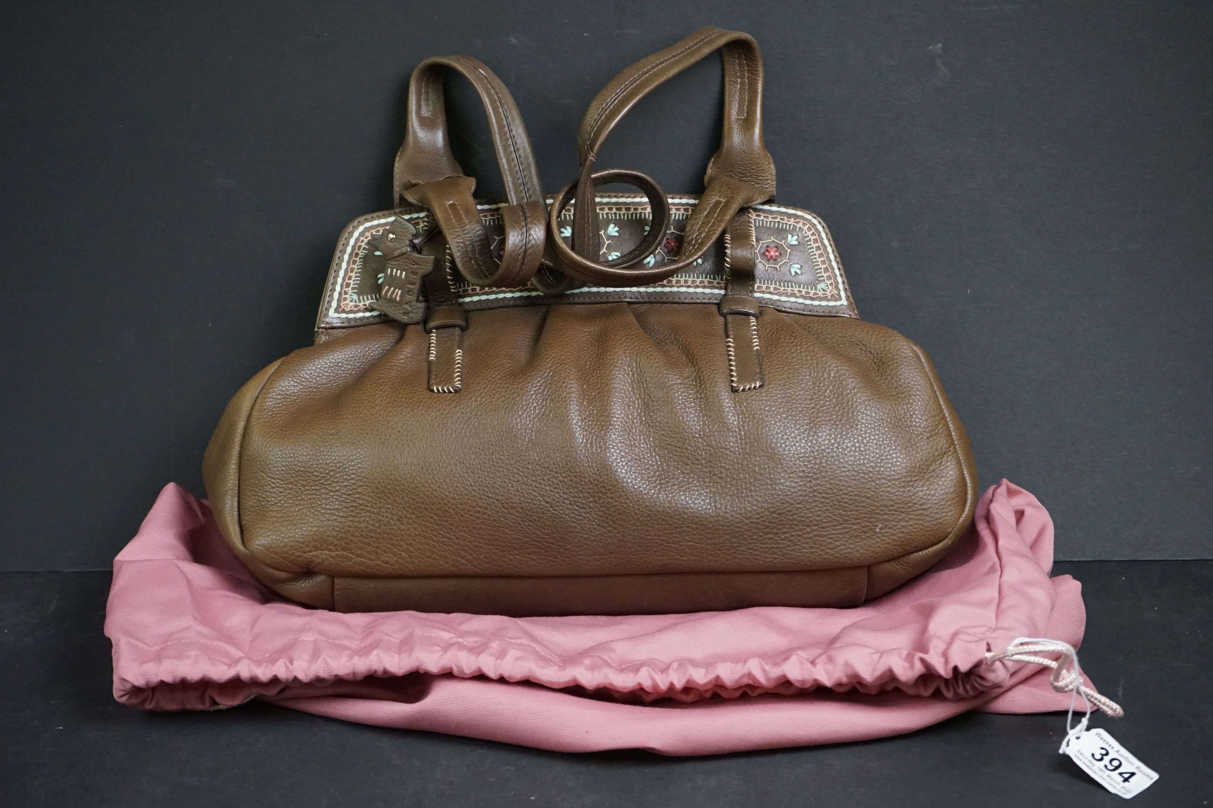 A brown Radley handbag with colourful detailing, brown Radley dog and pink dust bag.