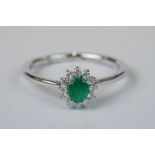 Platinum set emerald and diamond cluster ring of 60 points total