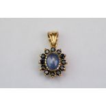 Star sapphire yellow gold cluster pendant, marks rubbed, the oval cabochon cut pale blue sapphire