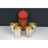 A set of four silver plated stirrup cups in brown leather case.