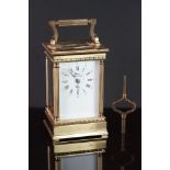 A French Rapport brass cased carriage clock with white enamel dial, complete with key.