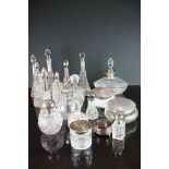 A large collection of antique silver topped scent bottle and vanity jars to include faux