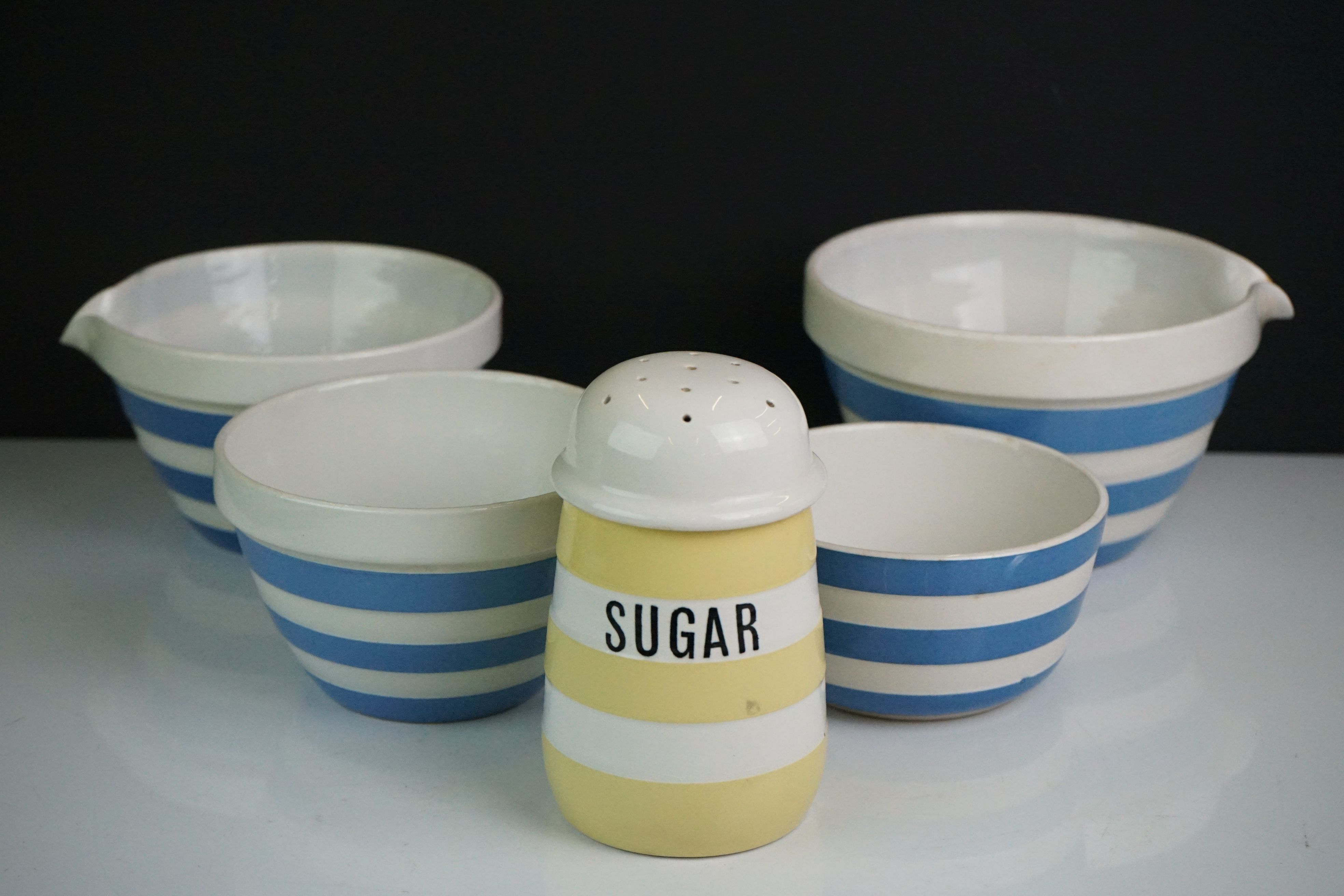 T G Green Cornishware including Yellow Sugar Shaker, Two Blue Pouring Bowls and Two further Blue