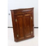 George III Mahogany Hanging Corner Cabinet, the two doors with shell inlay opening to three shaped