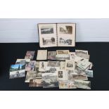 A collection of early to mid 20th century postcards within an album together with loose examples.