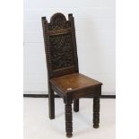 Victorian Jacobean Revival Oak Hall Chair, the arched rectangular back heavily carved with foliage