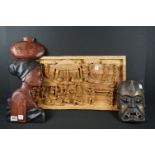 A group of carved wooden African tribal ornaments to include a mask and a carved figural panel.