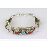 A white metal Native American Navajo bracelet with turquoise decoration.