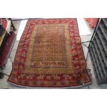Red Ground Rug decorated with squares of geometric patterns surrounded by a border parading men on