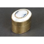 A brass pill box with decorative polished stone lid.