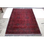 Eastern Wool Red Ground Rug with stylised floral decoration, 198cm x 130cm