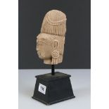 A stone Buddha head on black wooden plinth, stands approx 29cm in height