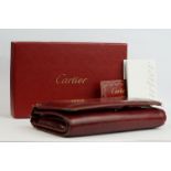 A ladies red leather Cartier purse complete with box and card.