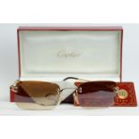 A pair of Cartier sunglasses complete with box and card.