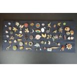Approx. 60 brooches & badges, displayed on cushioned board