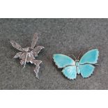 A silver and blue enamel butterfly brooch together with a silver fairy brooch.