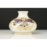 Moorcroft Pottery Squat Vase decorated in the Columbine pattern on white ground, impressed and green