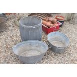 A large galvanised steel planter, height approx 52cm together with two small galvanised steel baths.