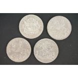 A collection of four British full crown coins to include two silver King George V 1935 rocking horse