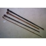 A collection of four carved wooden walking canes.