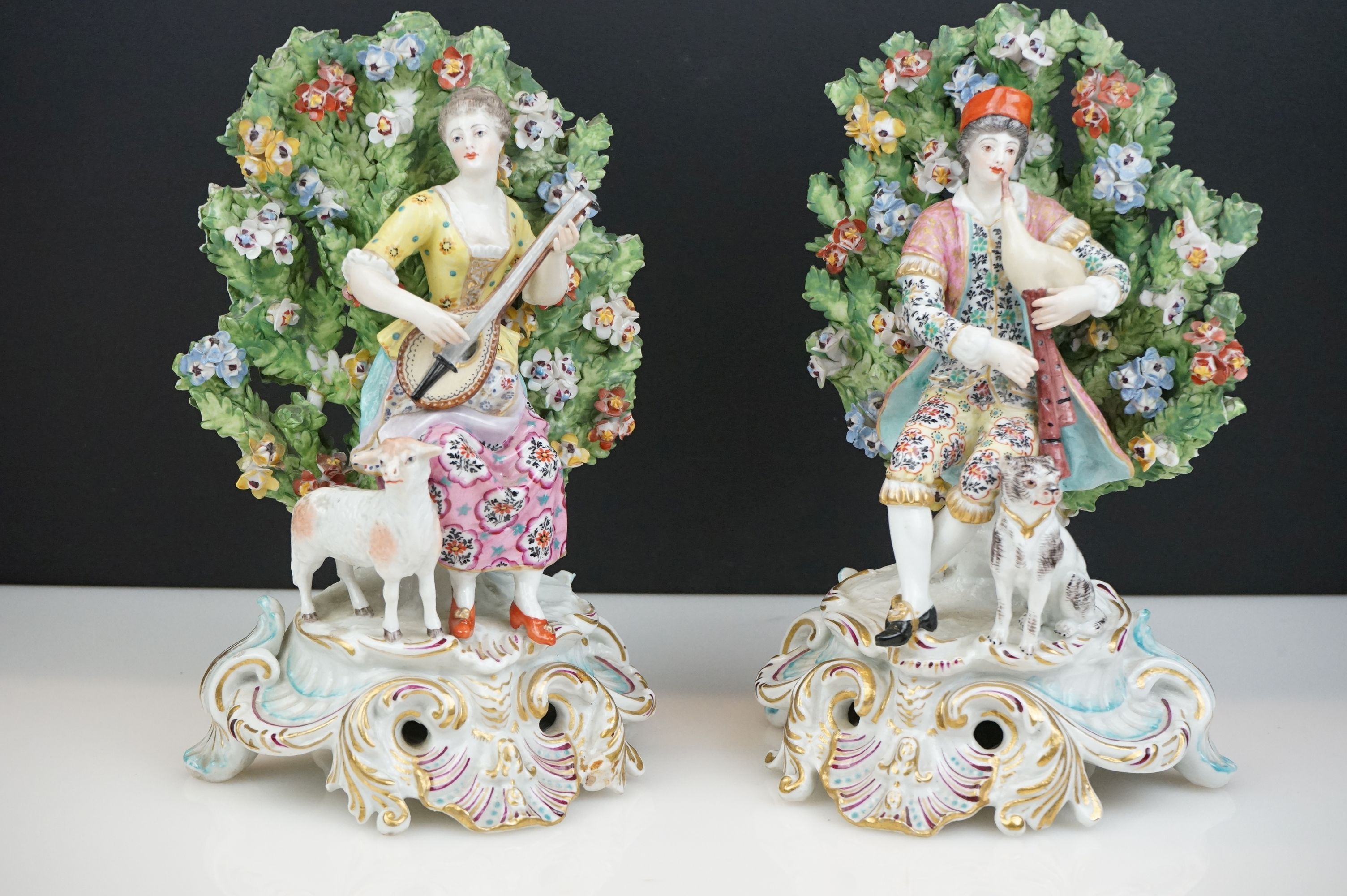 Pair of Chelsea Porcelain Bocage Figures in the form of a Man playing bagpipes with a dog and a