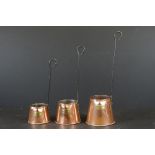 Set of Three Copper Graduating Cider Measures with iron hanging handles, tallest 39cm