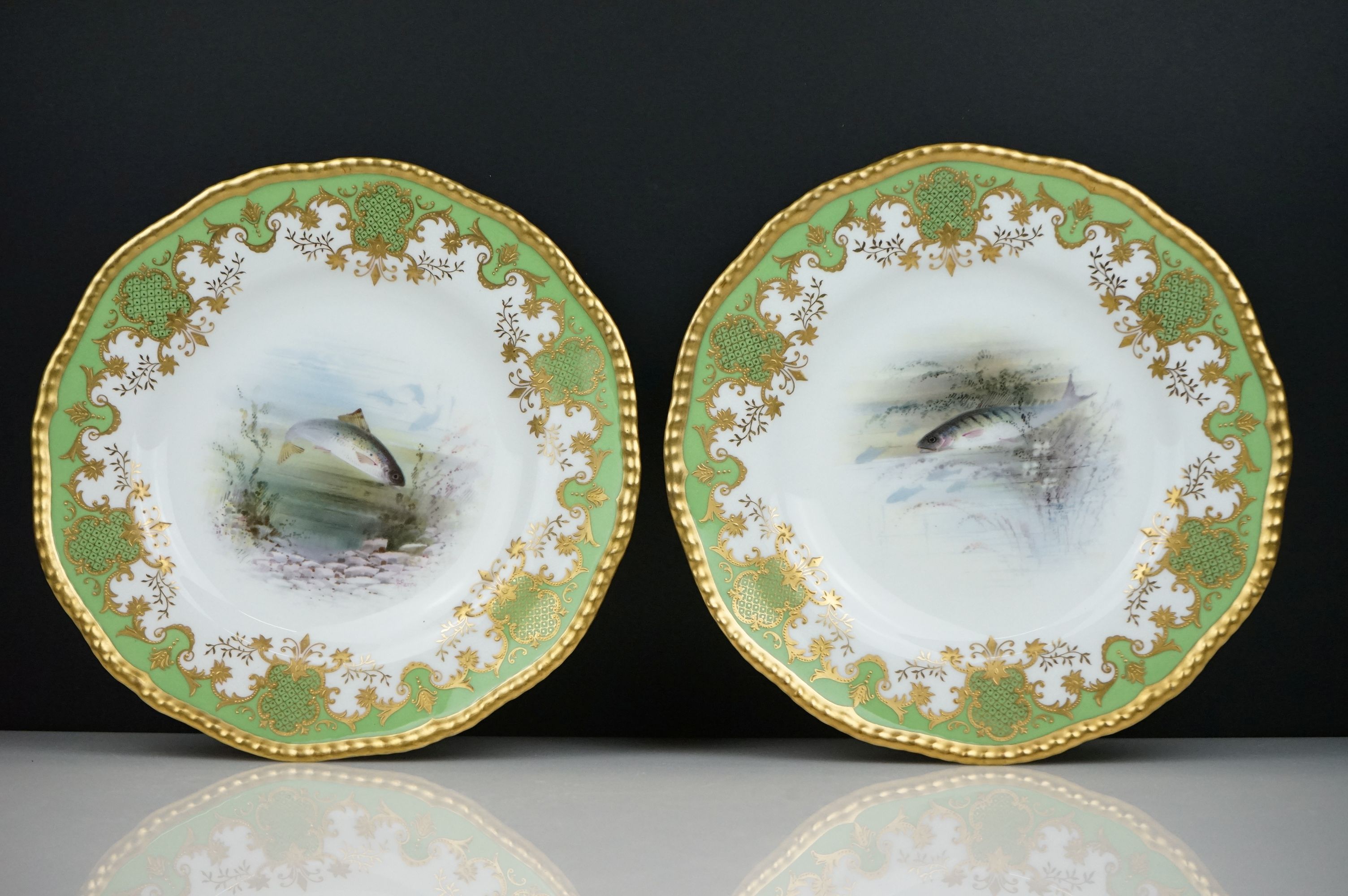 Pair of early 20th Century Coalport cabinet plates with green and gilt edged decoration, the centres