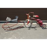 A 'Radio Flyer' red Childs tricycle together with a rocking horse.