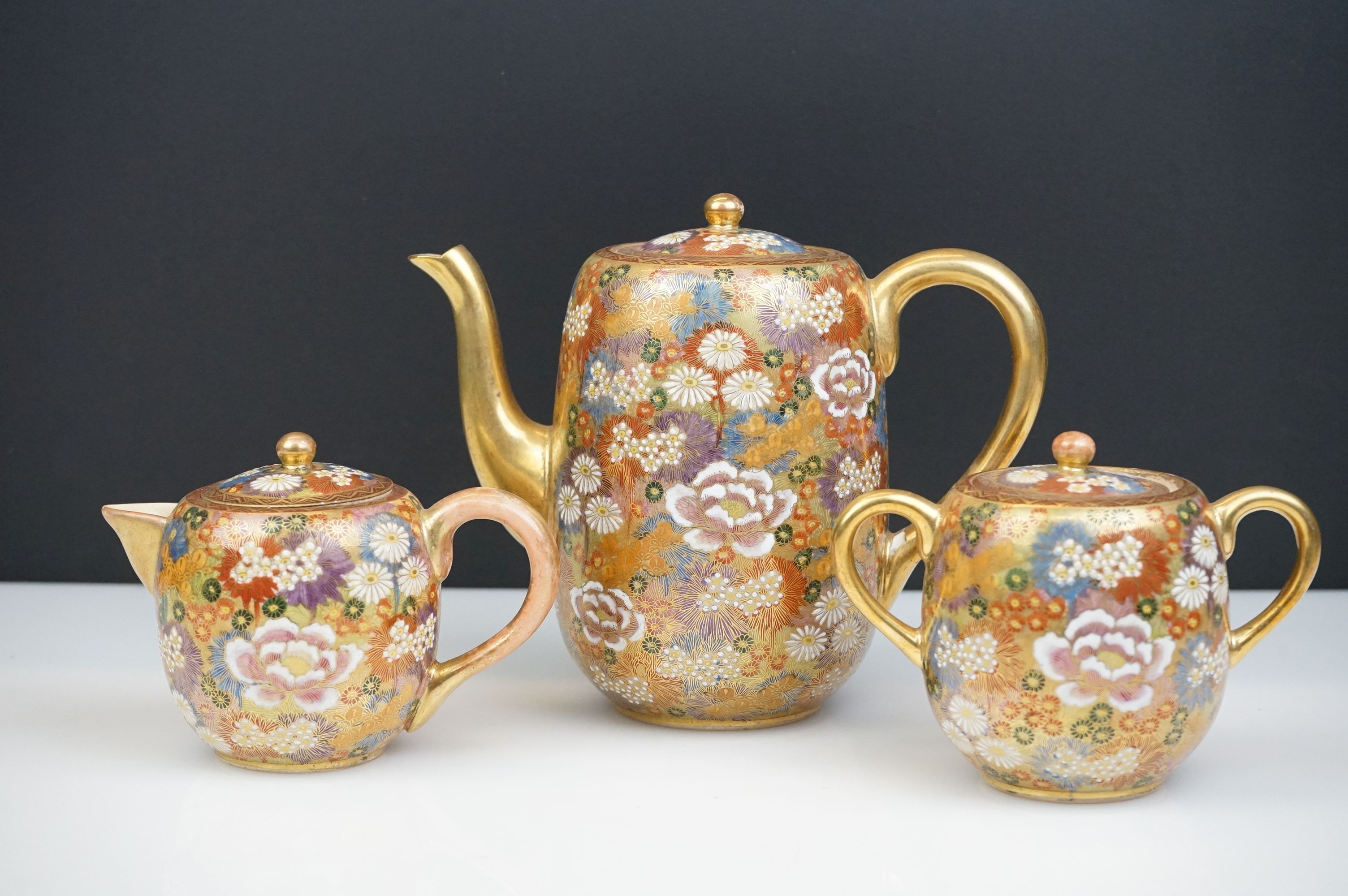 Japanese Satsuma Three Piece Coffee Set decorated with flowers on a gilt ground, marks to base,