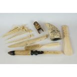 A mixed collection of carved bone collectables to include a paperknife and cocktail sticks.