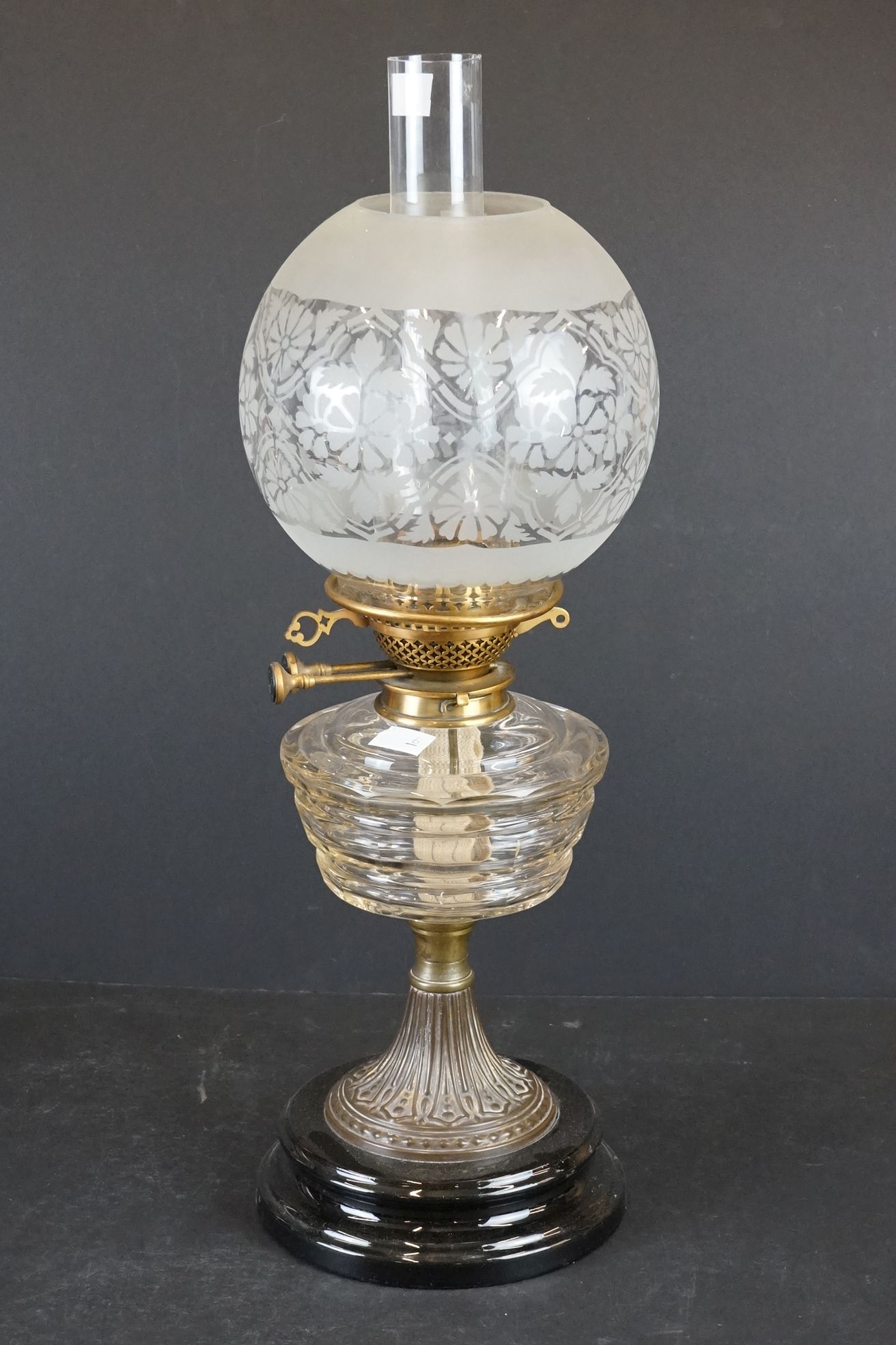 Late 19th / Early 20th century oil lamp with clear cut glass layered pattern font, brass base with