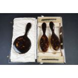 An early to mid 20th century faux tortoiseshell cased vanity set to include brushes, mirror, comb..
