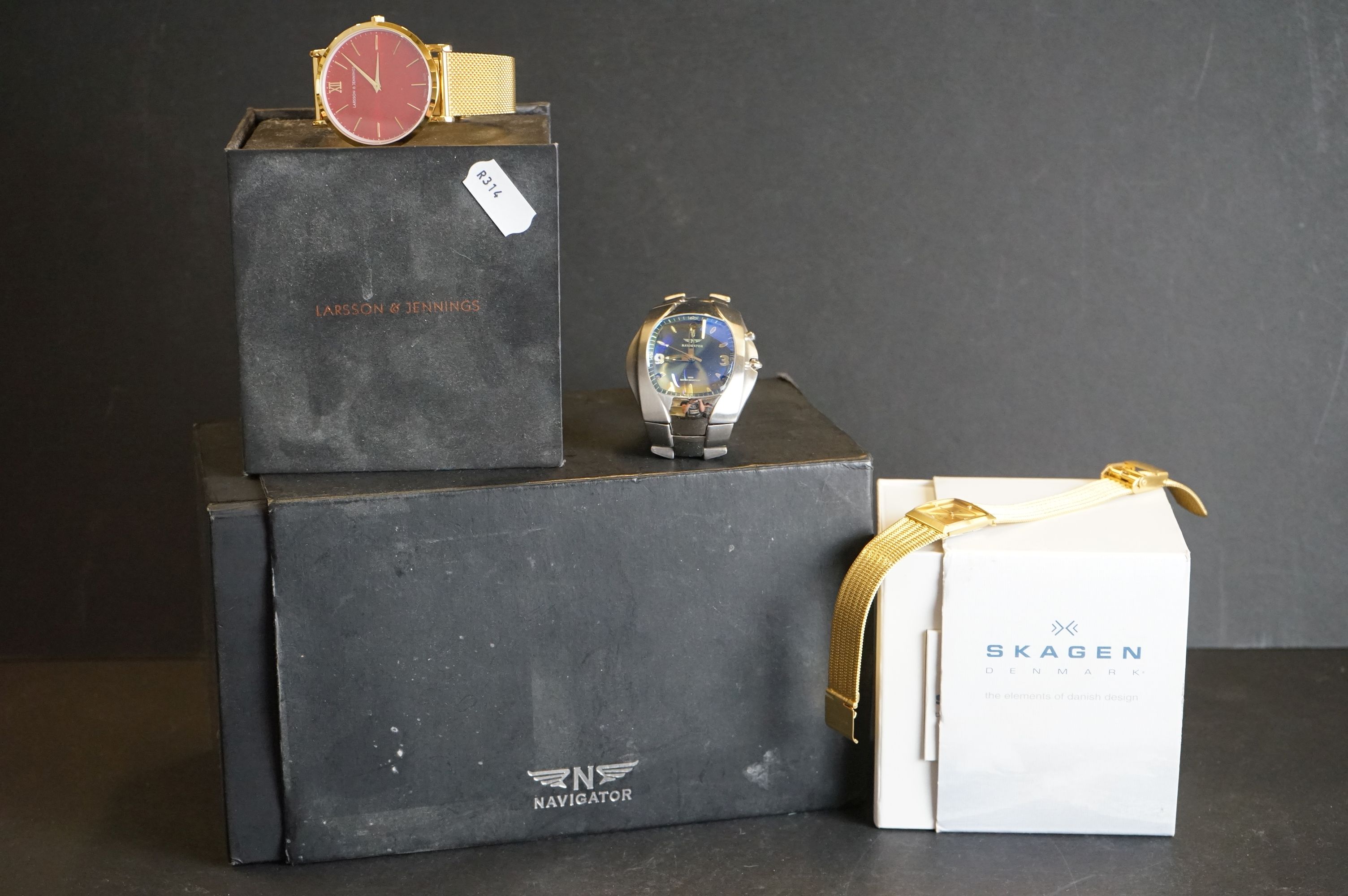 A collection of three cased gents watches to include Skagen, Navigator and Larsson & Jennings