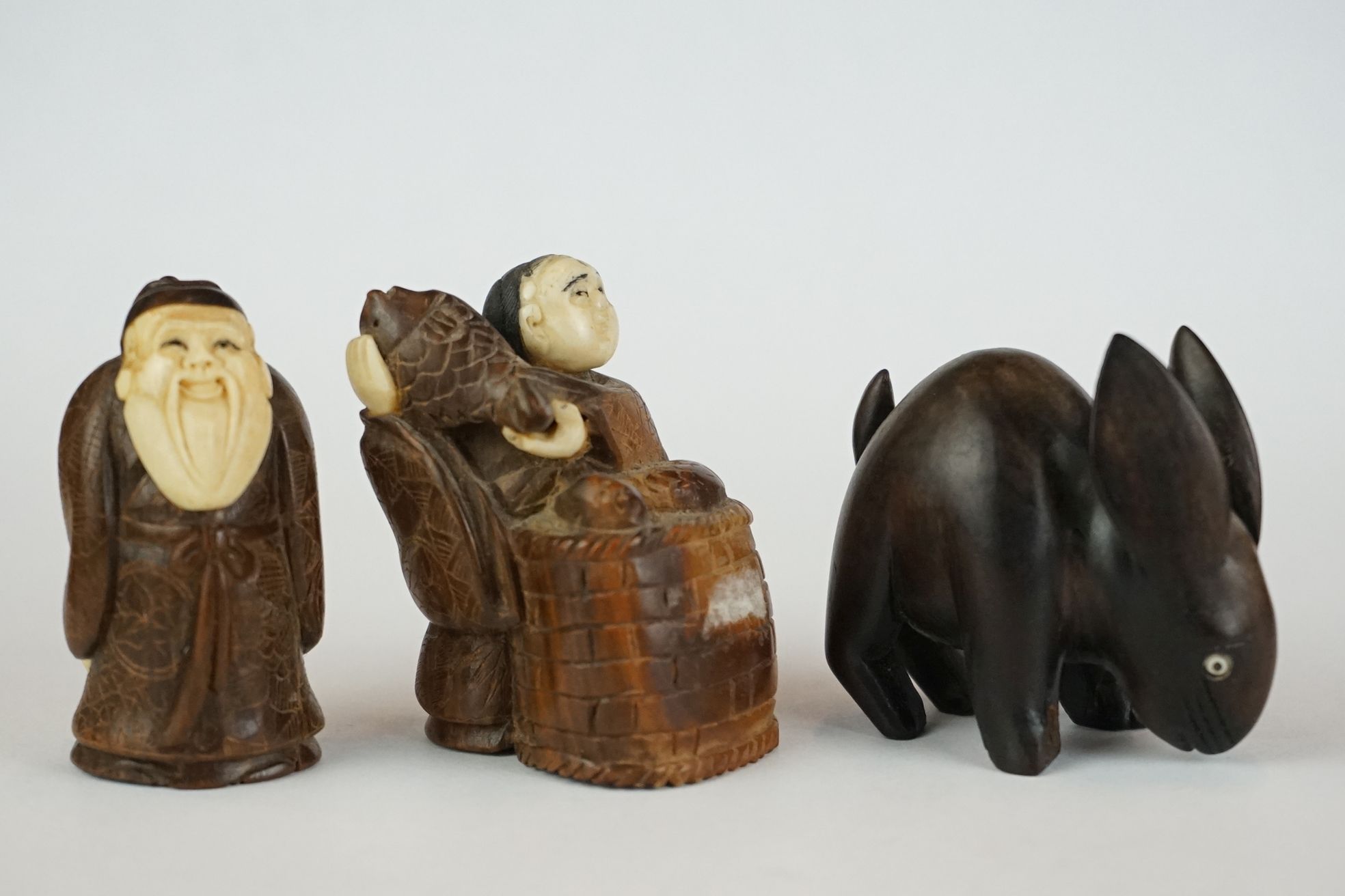 A collection of three hand carved wooden Chinese Netsuke to include a signed example.