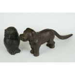 An antique cast iron nutcracker in the form of a dog together with a decorative lidded owl.