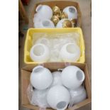 A large collection of white globe ceiling lights with brass fittings.