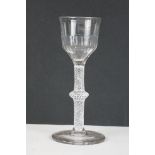 An antique 18th century wine glass with knotted stem and cotton twist, moulded bowl and plain foot.