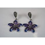 A pair of silver and enamel daisy style drop earrings.